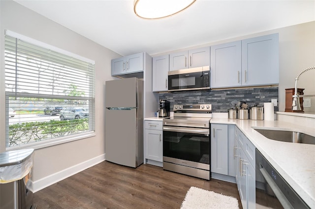 kitchen featuring dark hardwood / wood-style floors, tasteful backsplash, sink, gray cabinetry, and stainless steel appliances