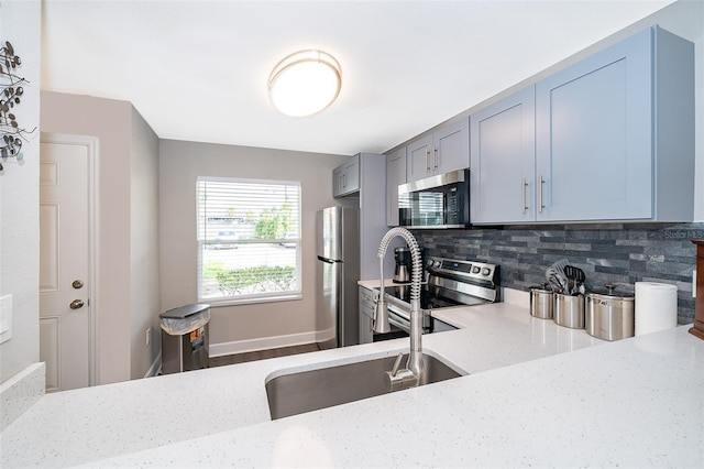 kitchen featuring appliances with stainless steel finishes, decorative backsplash, and light stone counters