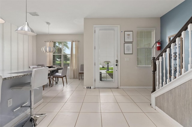 entryway with a chandelier and light tile patterned floors