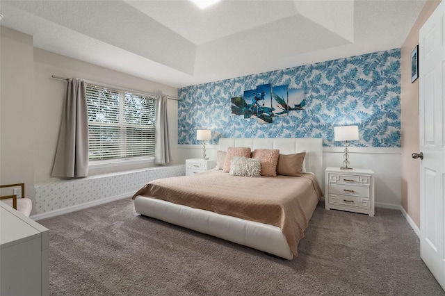 carpeted bedroom featuring a raised ceiling