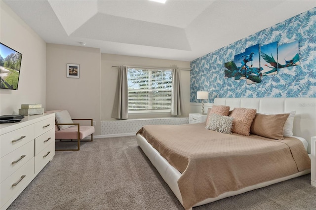 carpeted bedroom with a tray ceiling