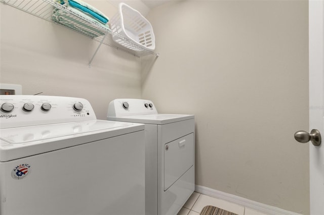 laundry area featuring light tile patterned floors and washing machine and dryer