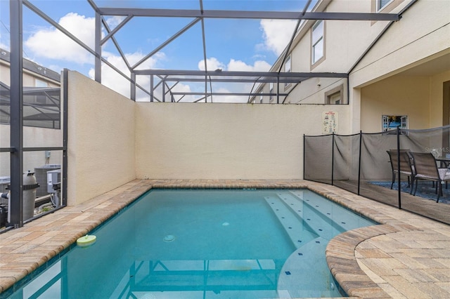 view of swimming pool featuring a patio and glass enclosure