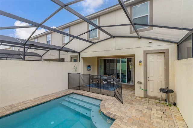 view of swimming pool featuring glass enclosure and a patio area