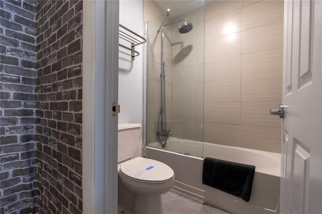 bathroom with tub / shower combination, toilet, and brick wall