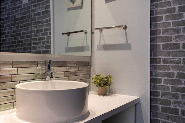 bathroom with brick wall and vanity