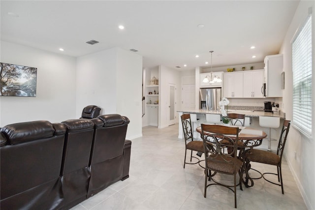 dining space featuring a notable chandelier and light tile patterned flooring