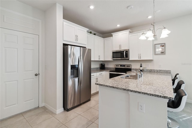 kitchen featuring appliances with stainless steel finishes, kitchen peninsula, white cabinetry, and pendant lighting