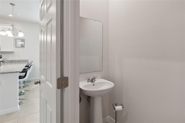 bathroom featuring tile patterned flooring, a chandelier, and sink