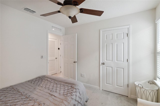 bedroom featuring light carpet, ceiling fan, and multiple windows