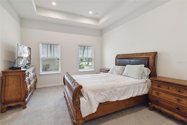 bedroom featuring a tray ceiling and light colored carpet