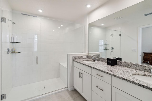 bathroom with walk in shower, vanity, and tile patterned flooring