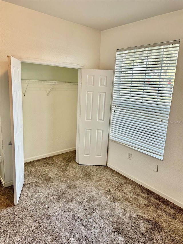 unfurnished bedroom with a closet and carpet floors