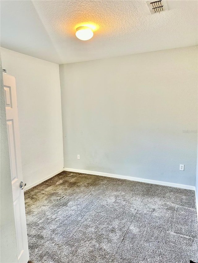 carpeted spare room featuring a textured ceiling