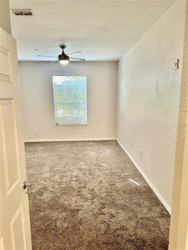 empty room featuring carpet, ceiling fan, and a textured ceiling