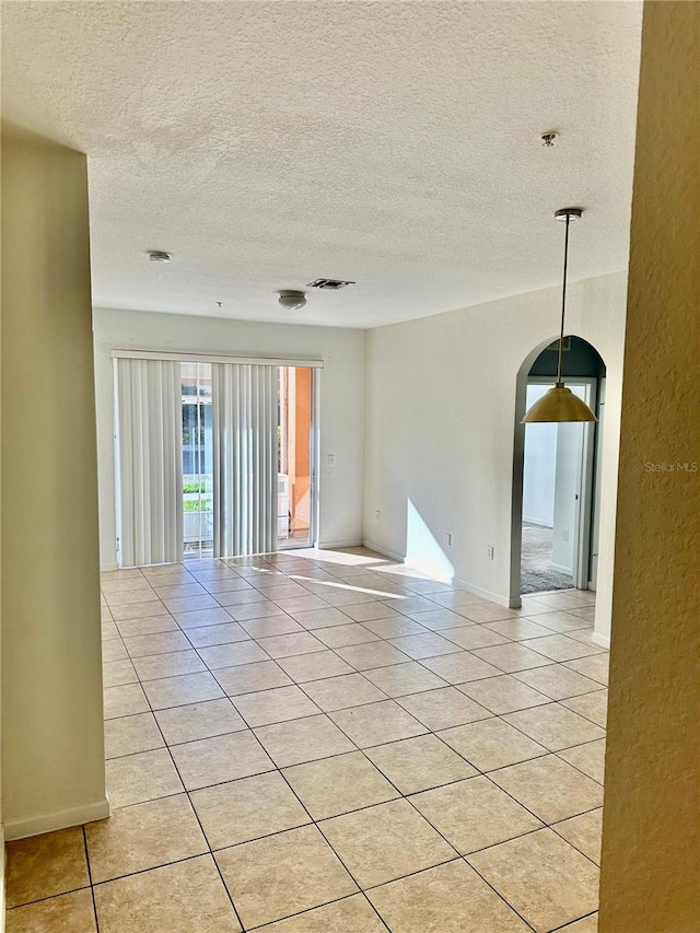 empty room featuring light tile patterned floors and a textured ceiling