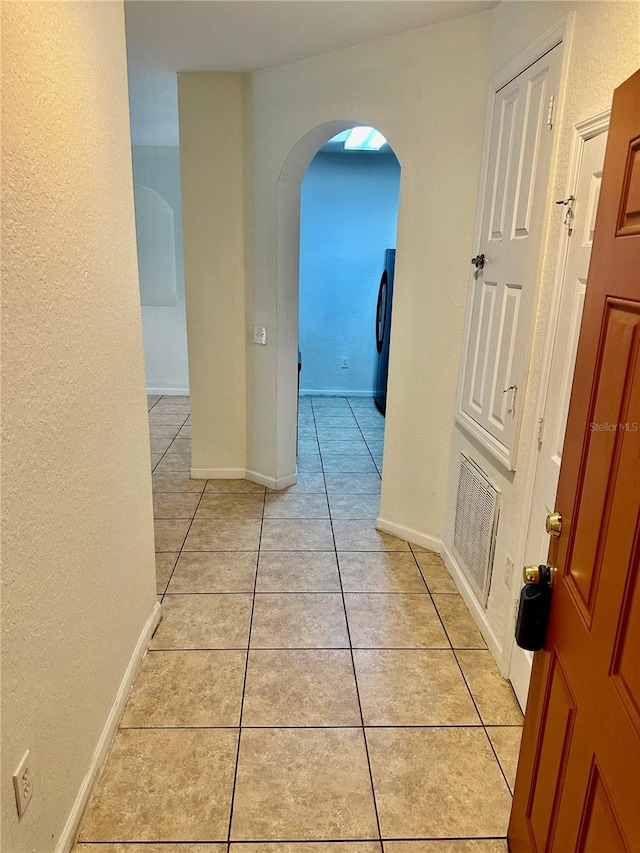 hall featuring light tile patterned flooring