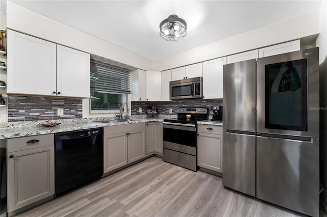 kitchen with gray cabinets, light hardwood / wood-style floors, appliances with stainless steel finishes, and sink