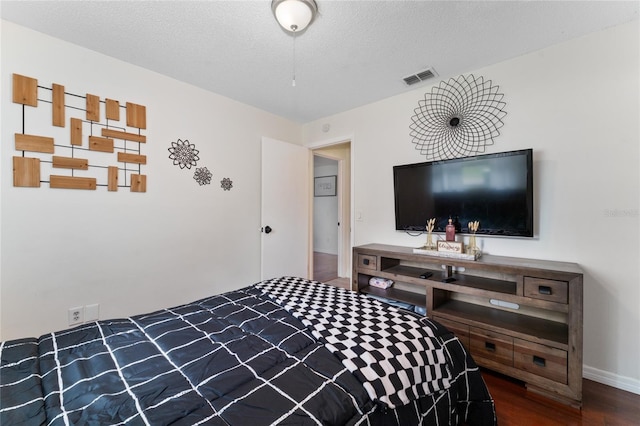 bedroom with a textured ceiling and hardwood / wood-style floors