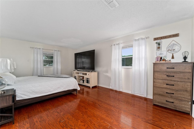 bedroom featuring a textured ceiling and dark hardwood / wood-style floors