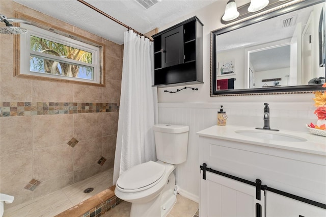 bathroom featuring vanity, a textured ceiling, tile patterned flooring, a shower with shower curtain, and toilet