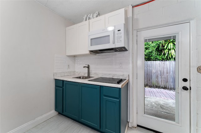 kitchen featuring white cabinets, sink, tasteful backsplash, a textured ceiling, and black electric cooktop