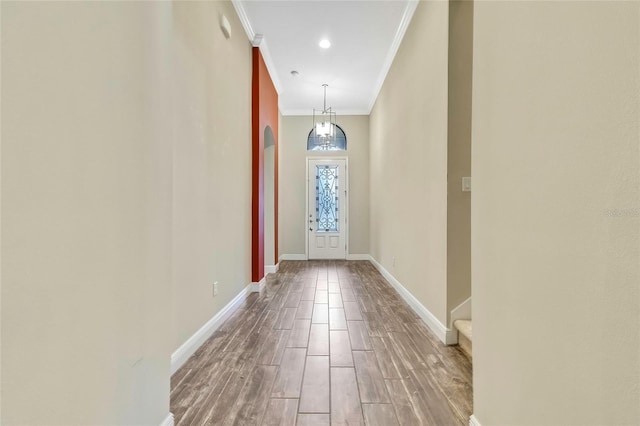 doorway with hardwood / wood-style flooring and ornamental molding