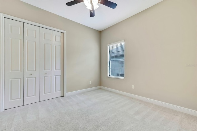 unfurnished bedroom with a closet, ceiling fan, and light colored carpet