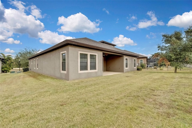 view of side of home featuring a lawn and a patio