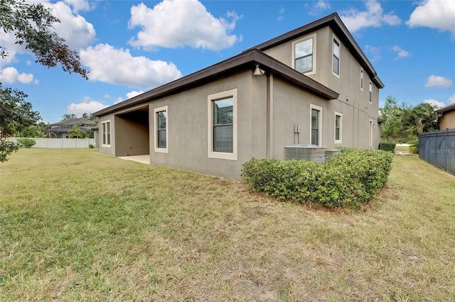 back of property featuring a yard, cooling unit, and a patio area