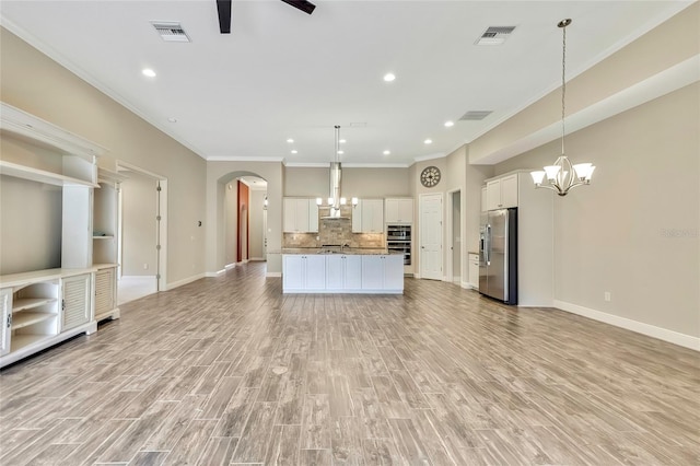 kitchen featuring white cabinetry, stainless steel fridge with ice dispenser, wall chimney exhaust hood, and hanging light fixtures