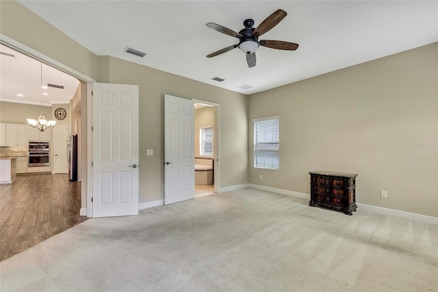 unfurnished bedroom with ceiling fan with notable chandelier, crown molding, ensuite bath, light hardwood / wood-style flooring, and stainless steel refrigerator