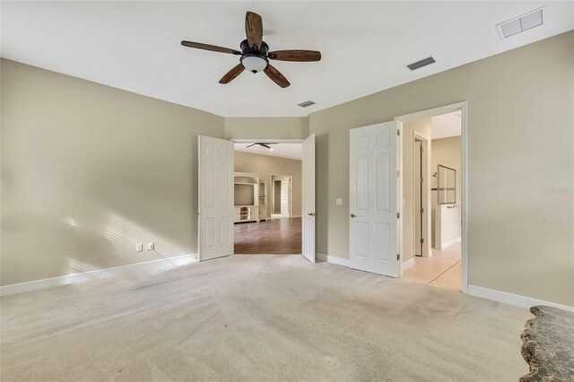 unfurnished bedroom featuring ceiling fan and light colored carpet