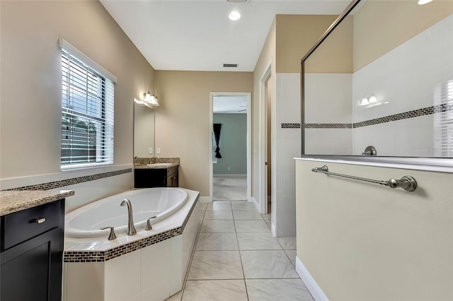 bathroom with tiled bath, ceiling fan, and vanity