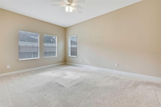 carpeted spare room with ceiling fan