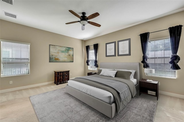 carpeted bedroom with multiple windows and ceiling fan