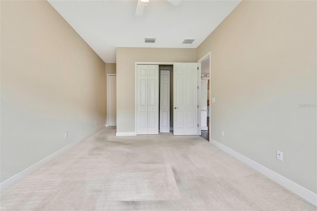 unfurnished bedroom with light carpet, a closet, and ceiling fan