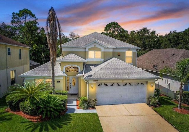 view of front of house featuring a garage and a yard