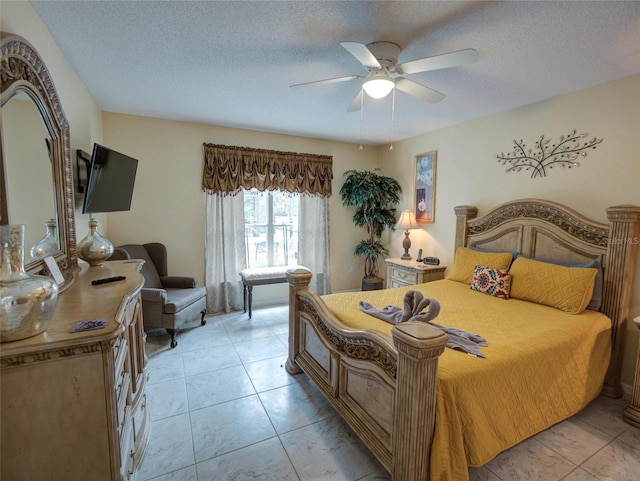 tiled bedroom with ceiling fan and a textured ceiling