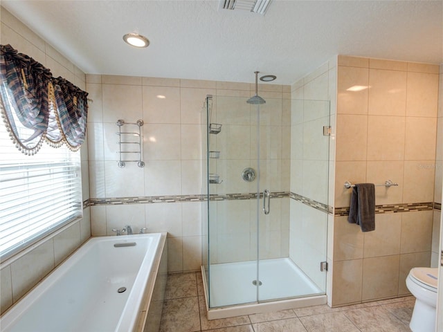 bathroom with tile walls, separate shower and tub, tile patterned floors, and toilet