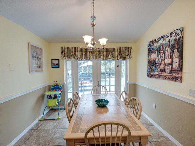 dining room with an inviting chandelier, vaulted ceiling, and light tile patterned floors