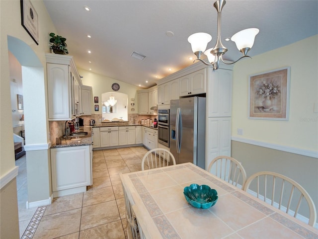 dining space featuring light tile patterned floors, sink, and a chandelier