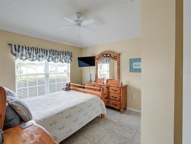 bedroom featuring ceiling fan and a textured ceiling