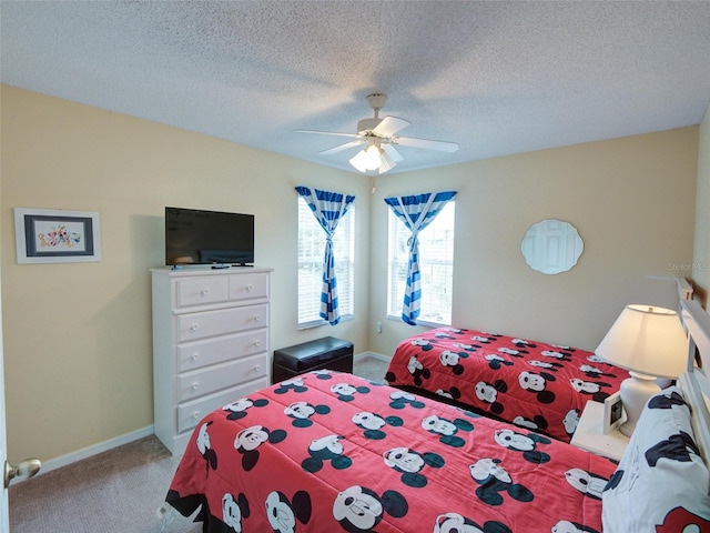 bedroom with ceiling fan, carpet floors, and a textured ceiling