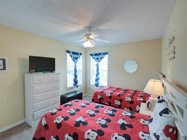 bedroom with ceiling fan, carpet floors, and a textured ceiling