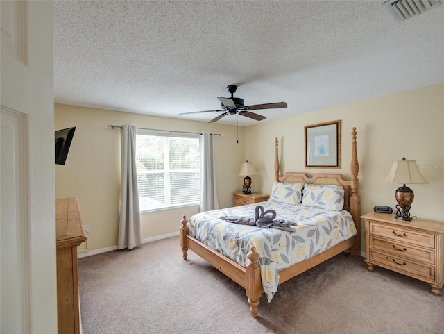 carpeted bedroom with ceiling fan and a textured ceiling