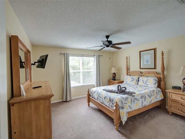 carpeted bedroom with ceiling fan and a textured ceiling