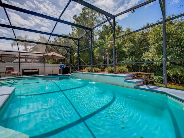 view of pool with pool water feature and glass enclosure