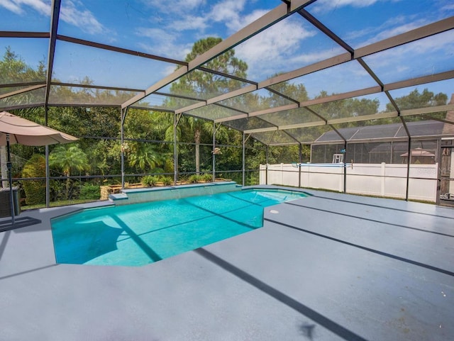 view of swimming pool featuring glass enclosure and a patio