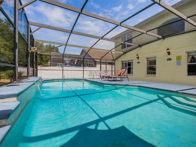 view of swimming pool featuring glass enclosure, a patio, and pool water feature